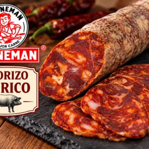 Un chorizo ibérico expuesto con algunas lonchas cortadas, sobre un plato